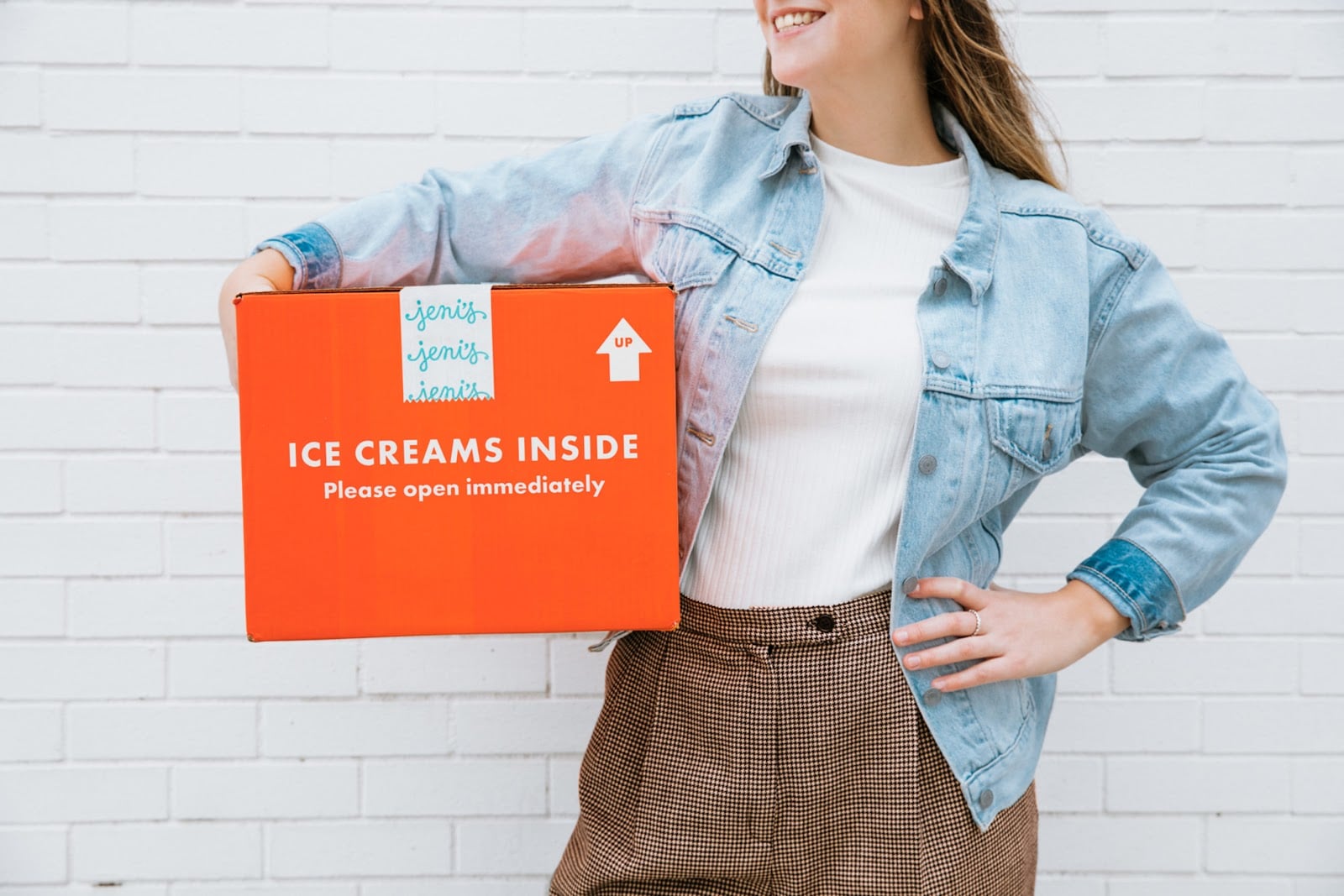 Customer holds delivery box and is happy with prompt arrival of order